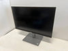 Black computer monitor on a white surface with a white wall background