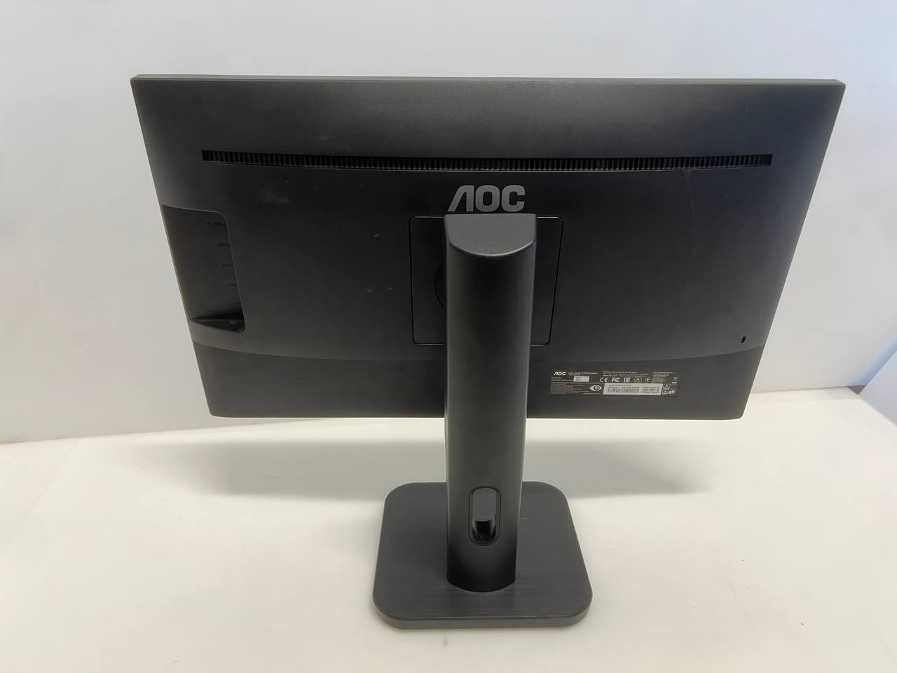 Black computer monitor with stand on a white surface