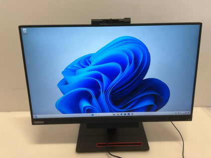 Computer monitor with blue abstract design on screen, placed on a white surface.